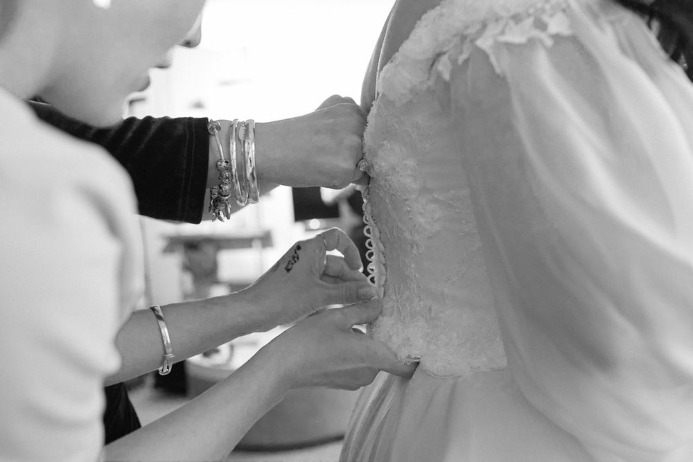 Detail shots of wedding dress preparations and final adjustments.