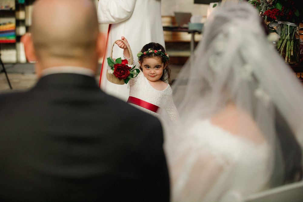 Wedding ceremony processional with bride in white dress walking down church aisle.