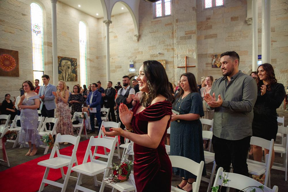 Church congregation gathered for a wedding ceremony under vaulted ceilings.