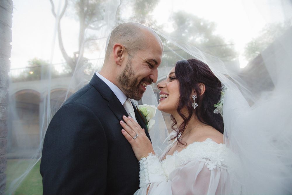 Romantic foggy wedding portrait with couple embracing outdoors.