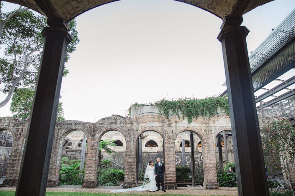 Historic brick archways and columns create an elegant outdoor architectural setting.