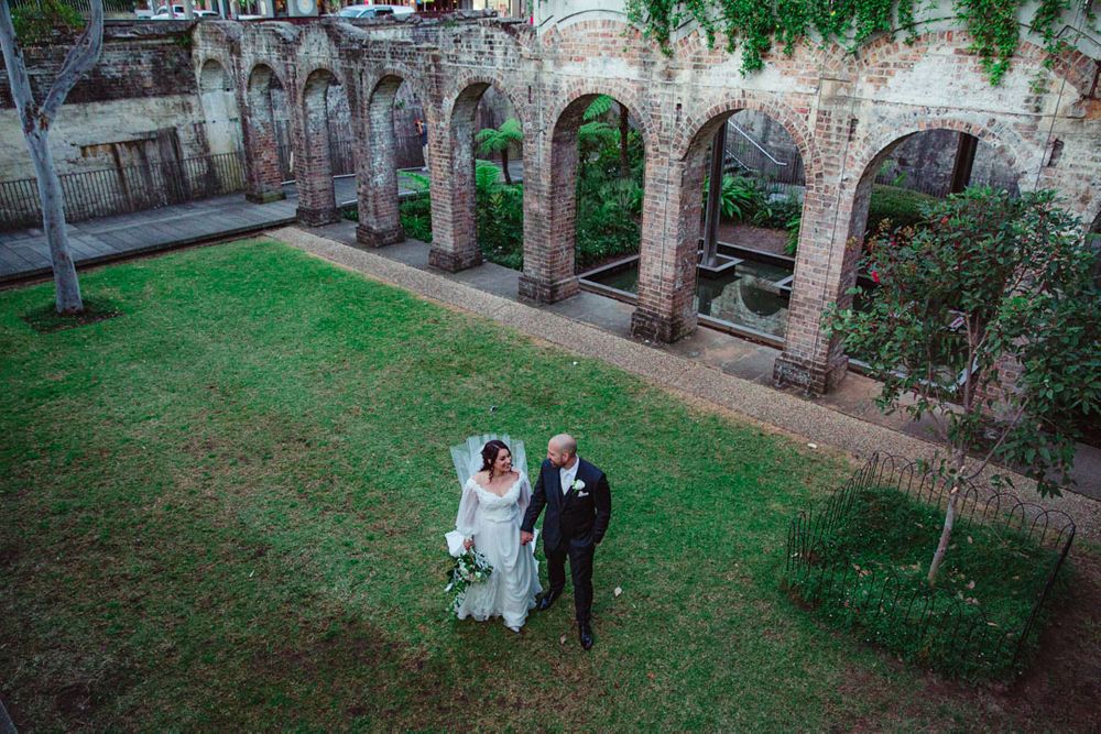 Aerial view of a wedding celebration in a rustic brick courtyard setting.