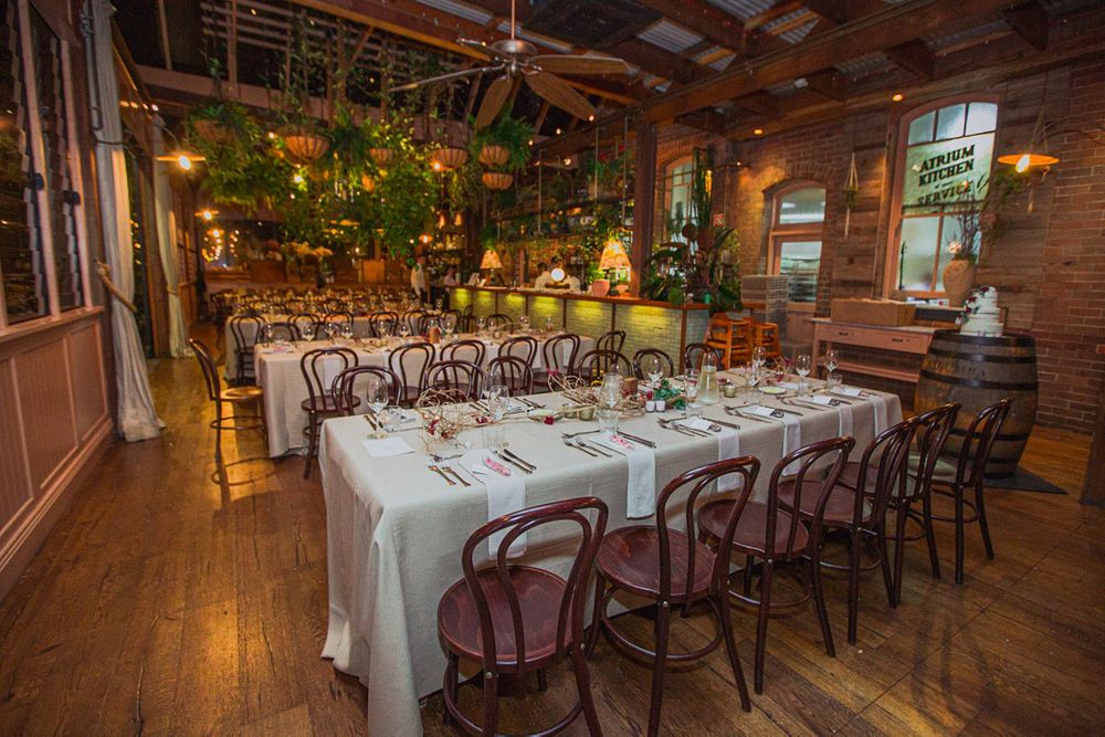 Rustic wooden reception hall with elegant table settings and warm lighting.