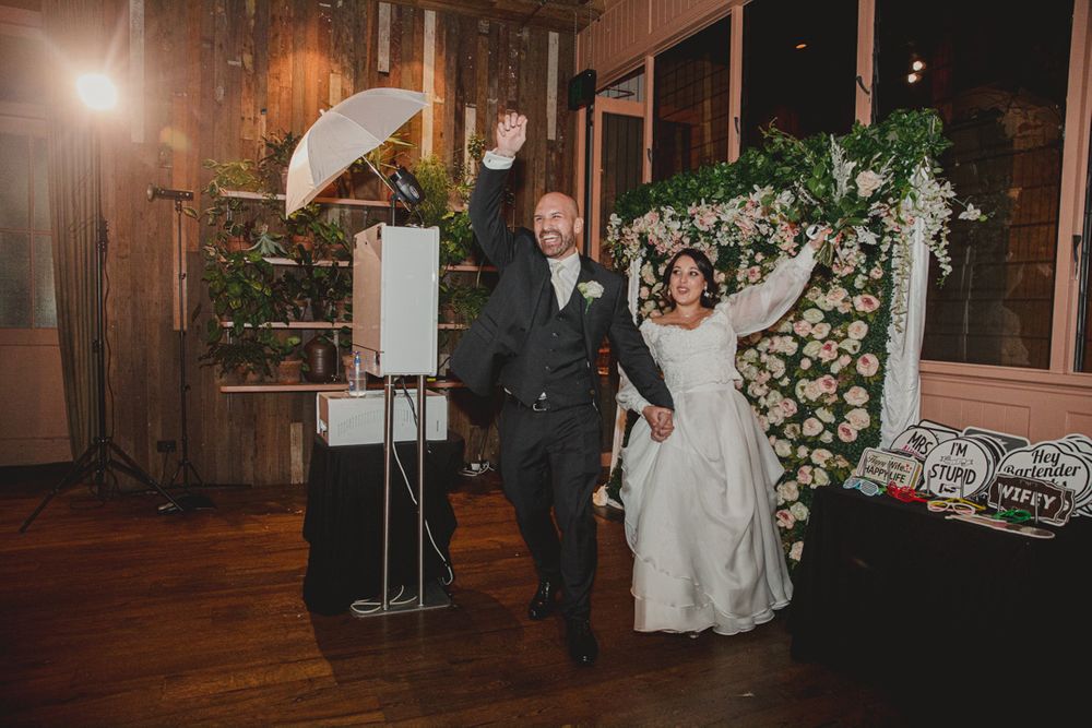 Couple sharing their first dance at a wedding reception with floral decorations.