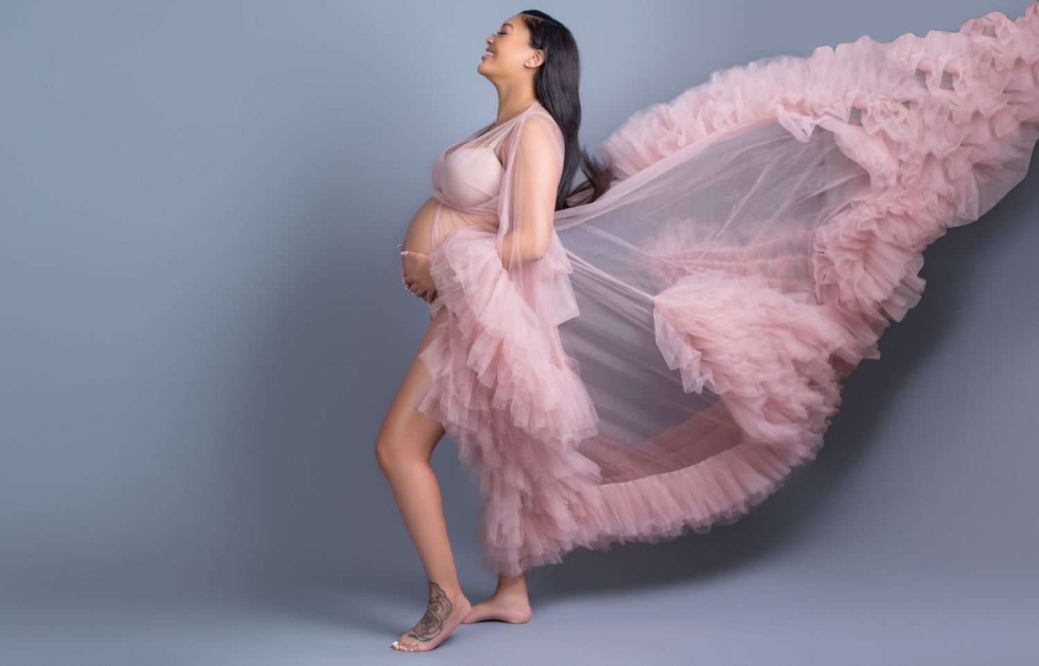 DMV Black Female Photographer captures flowing dress maternity photos in a studio in Annapolis, MD