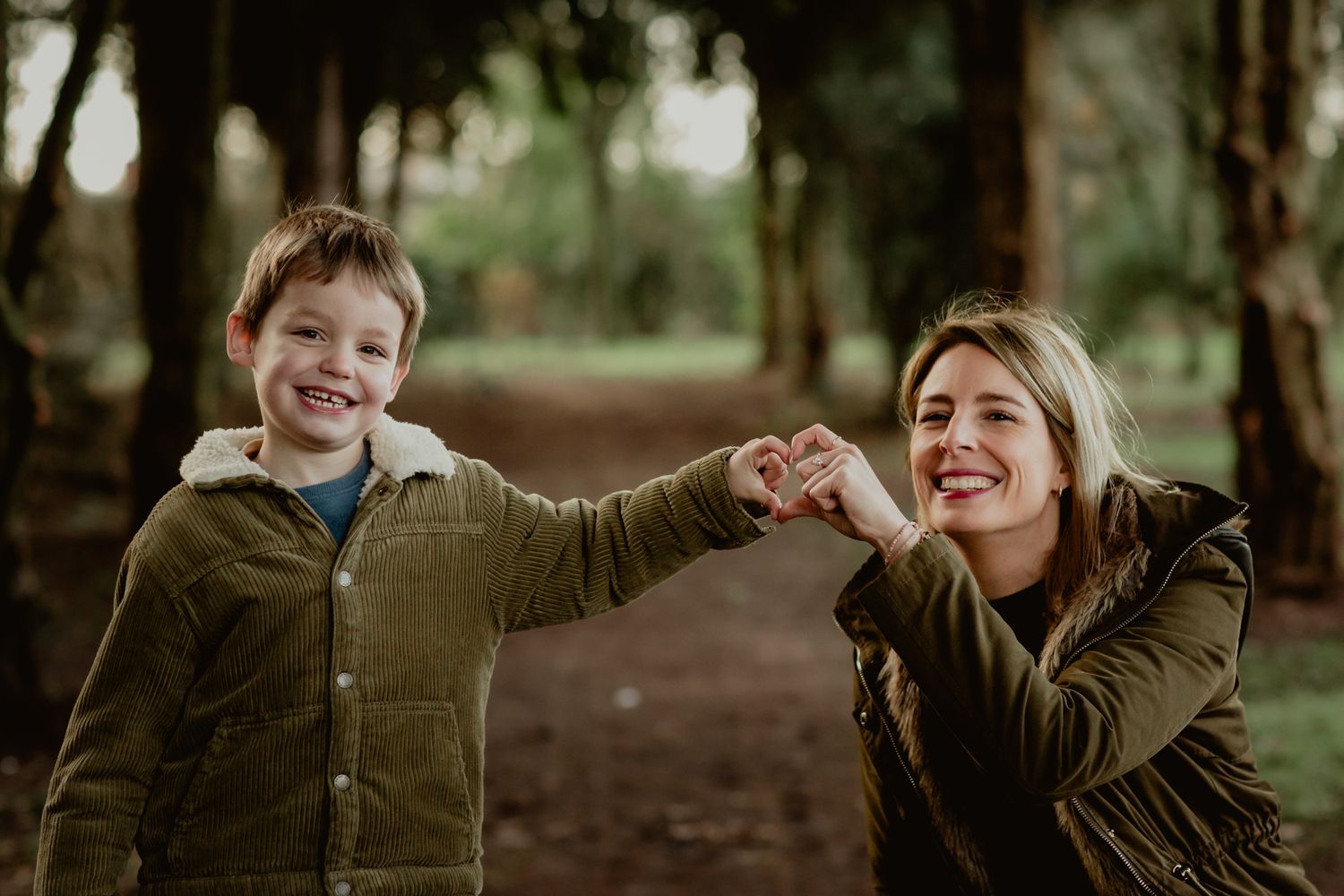 Two people sharing a joyful moment while playing outdoors in a wooded setting.