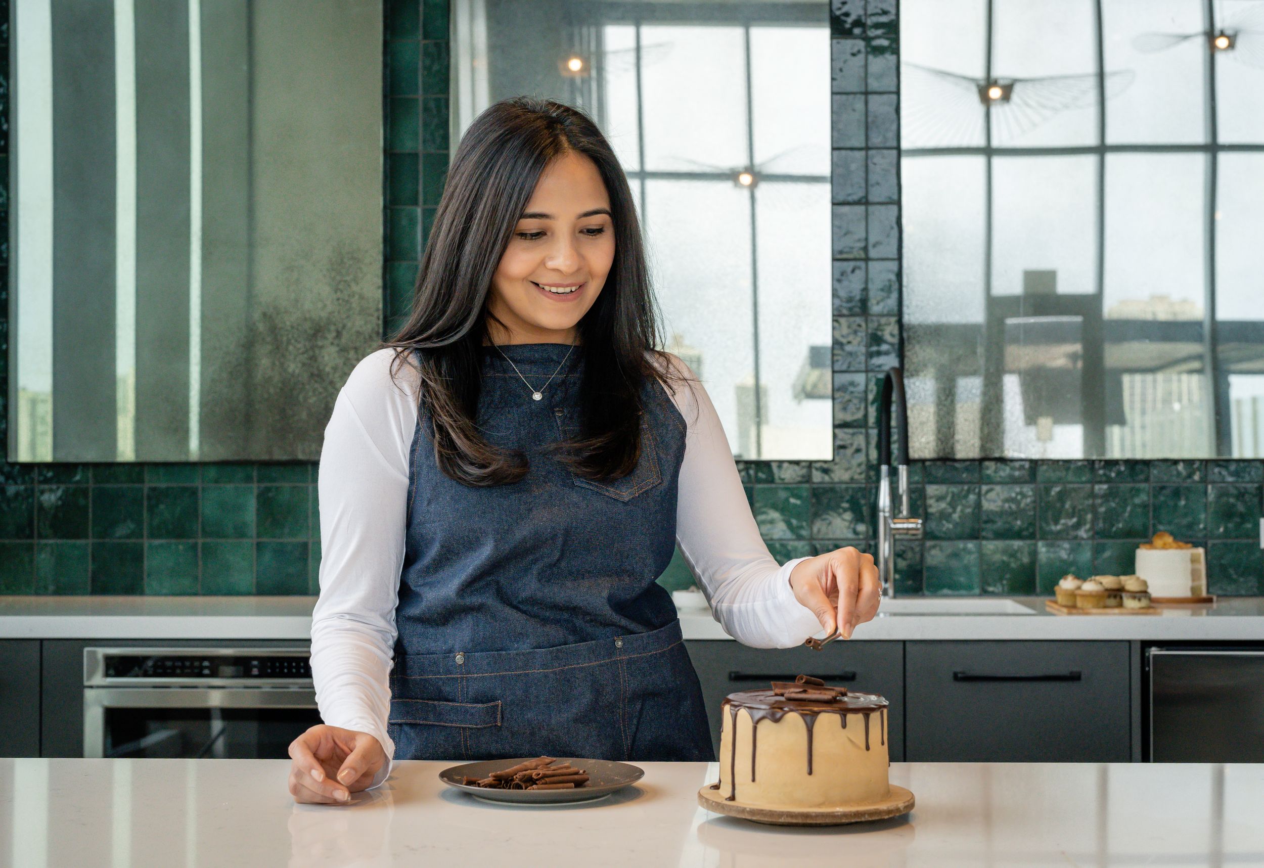 Person sitting at modern desk with laptop and golden cake.