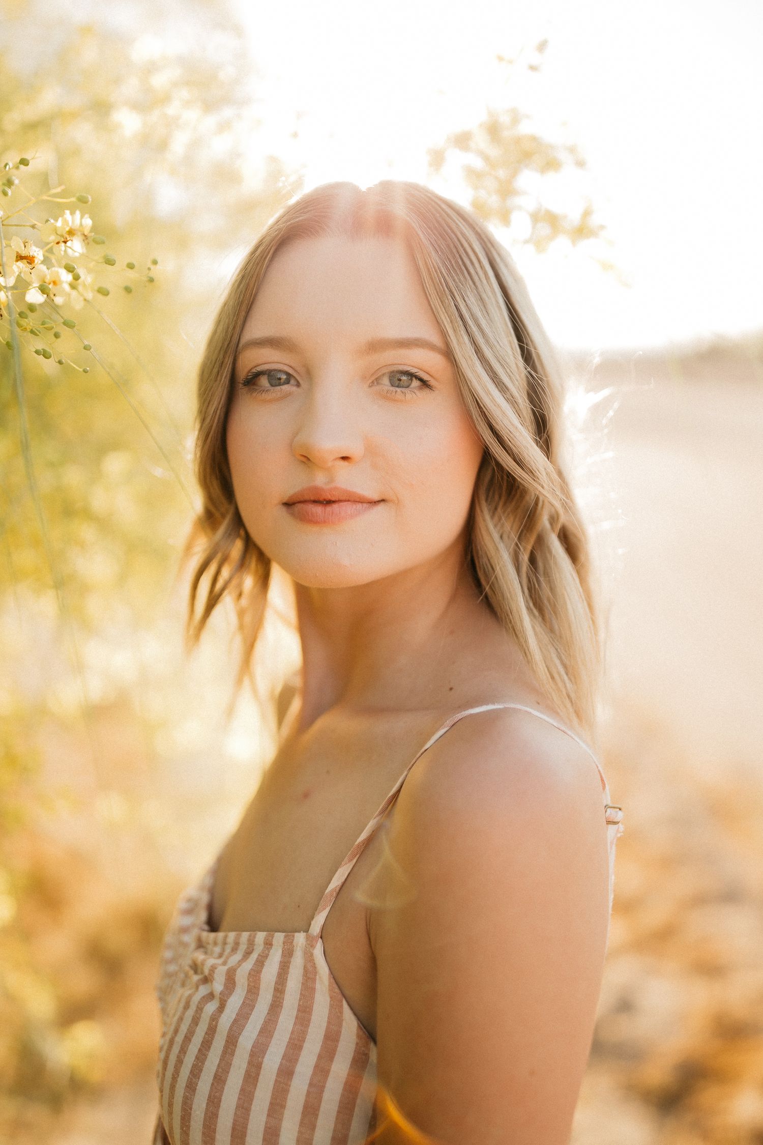 Golden hour portrait in striped sundress with natural lighting.