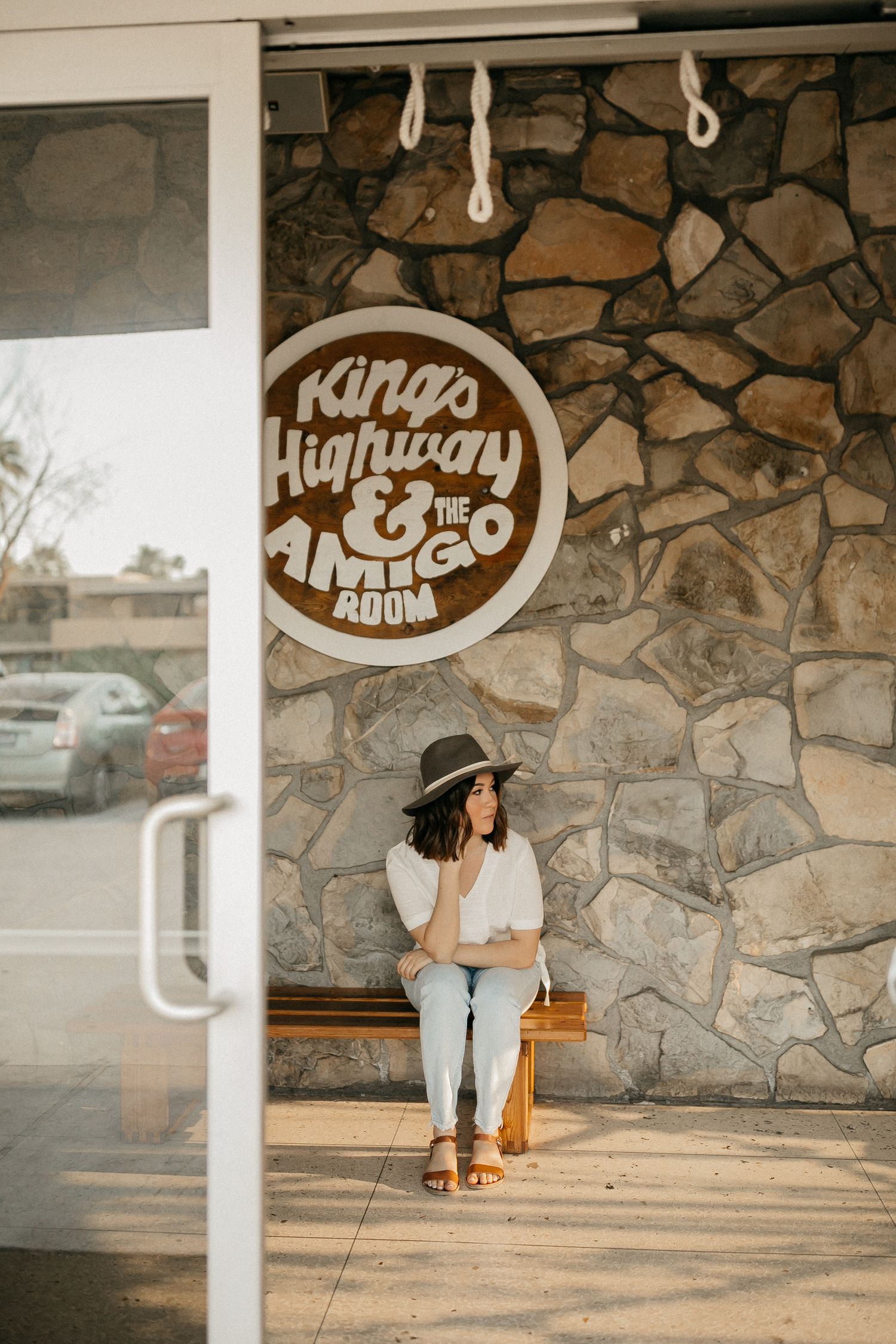 Vintage style storefront with stone wall and circular logo reading Kings Highway.