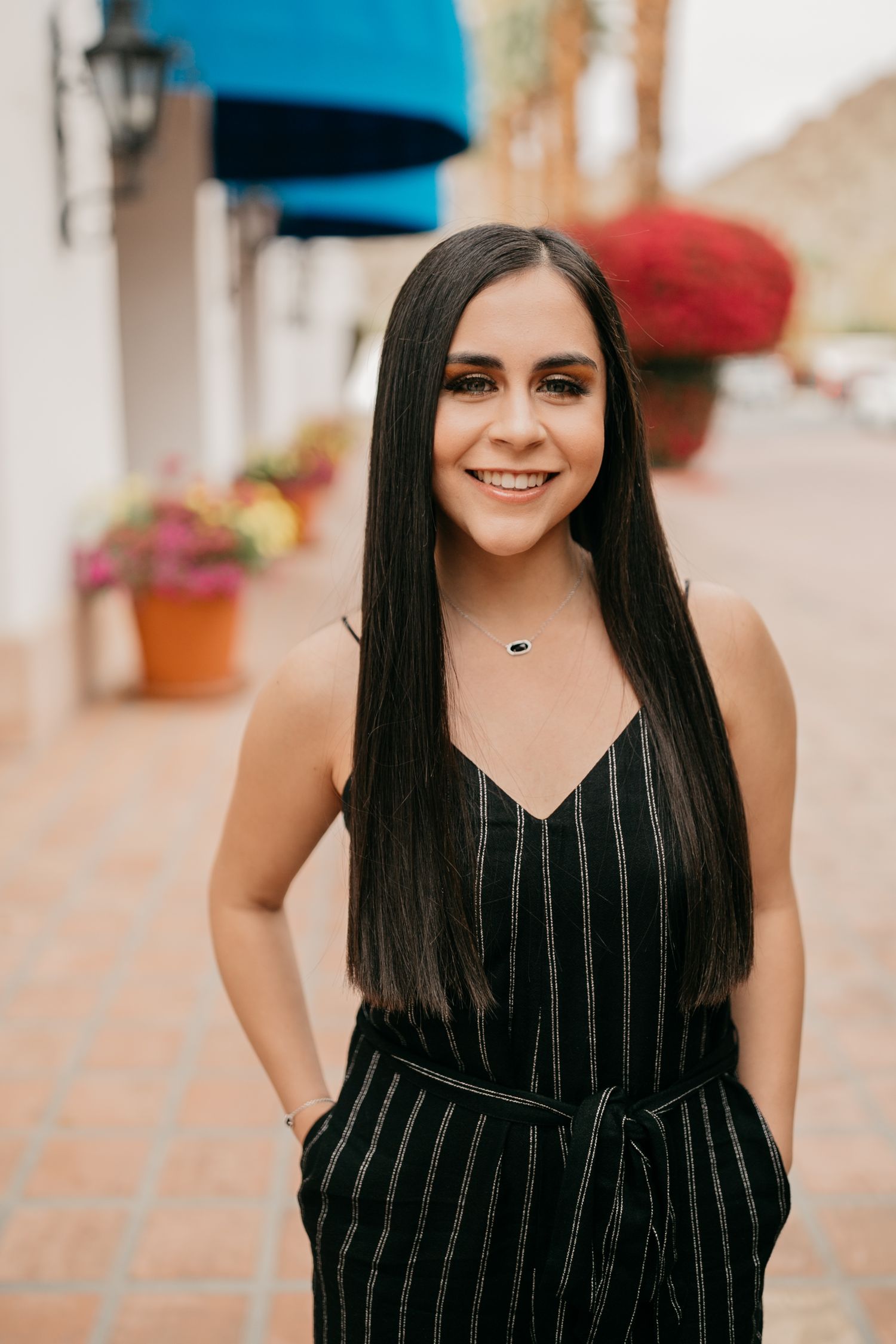 Street portrait in pinstriped black jumpsuit with urban background.