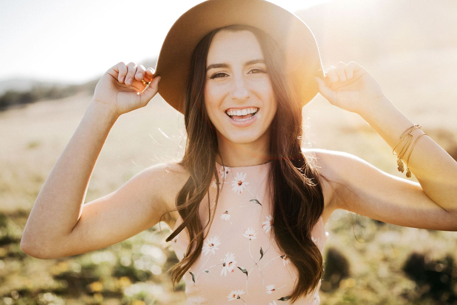 Joyful summer moment with hat and sunlight in an outdoor natural setting.
