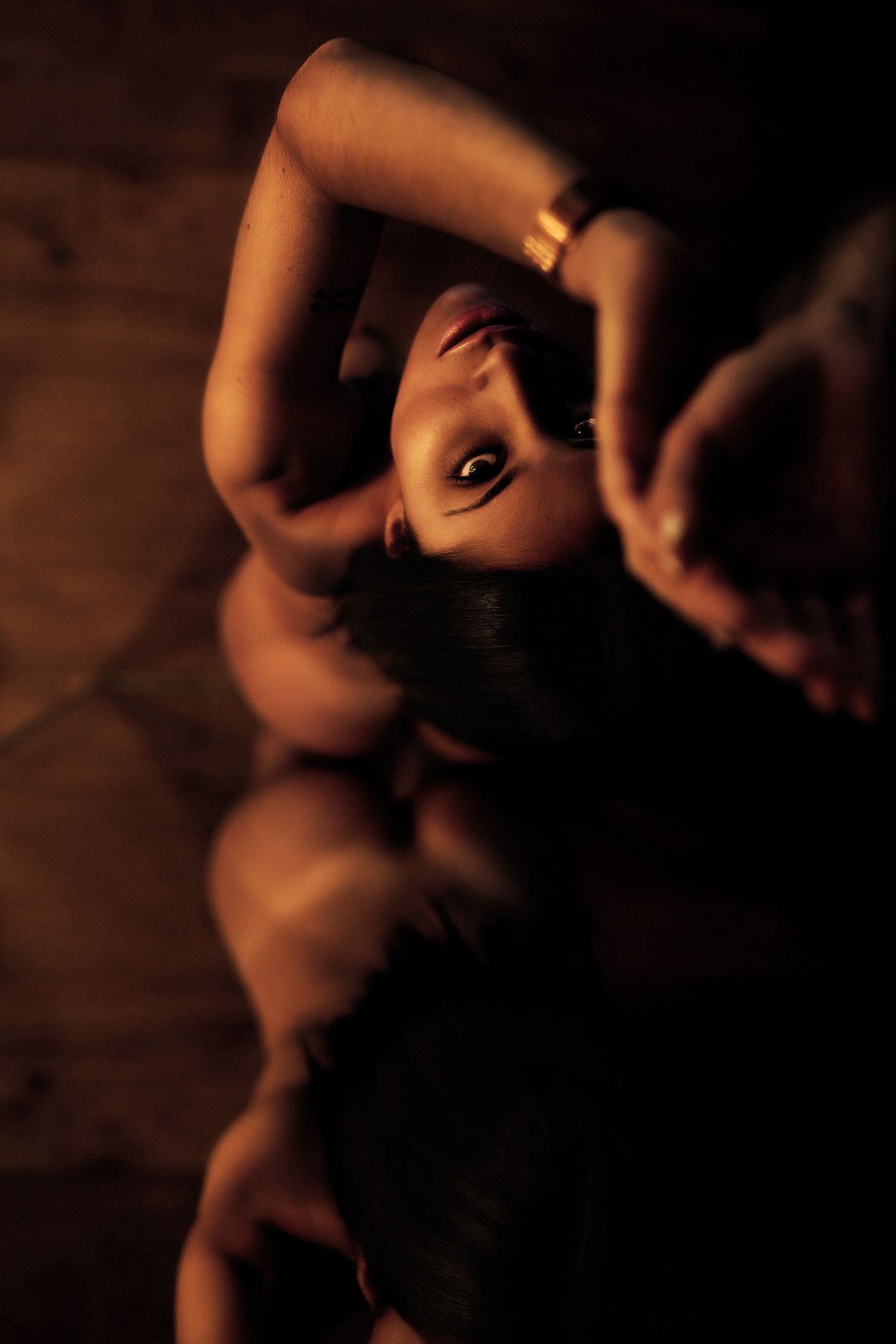 Spanish woman standing naked in front of mirror looking up at camera with her beautiful eyes