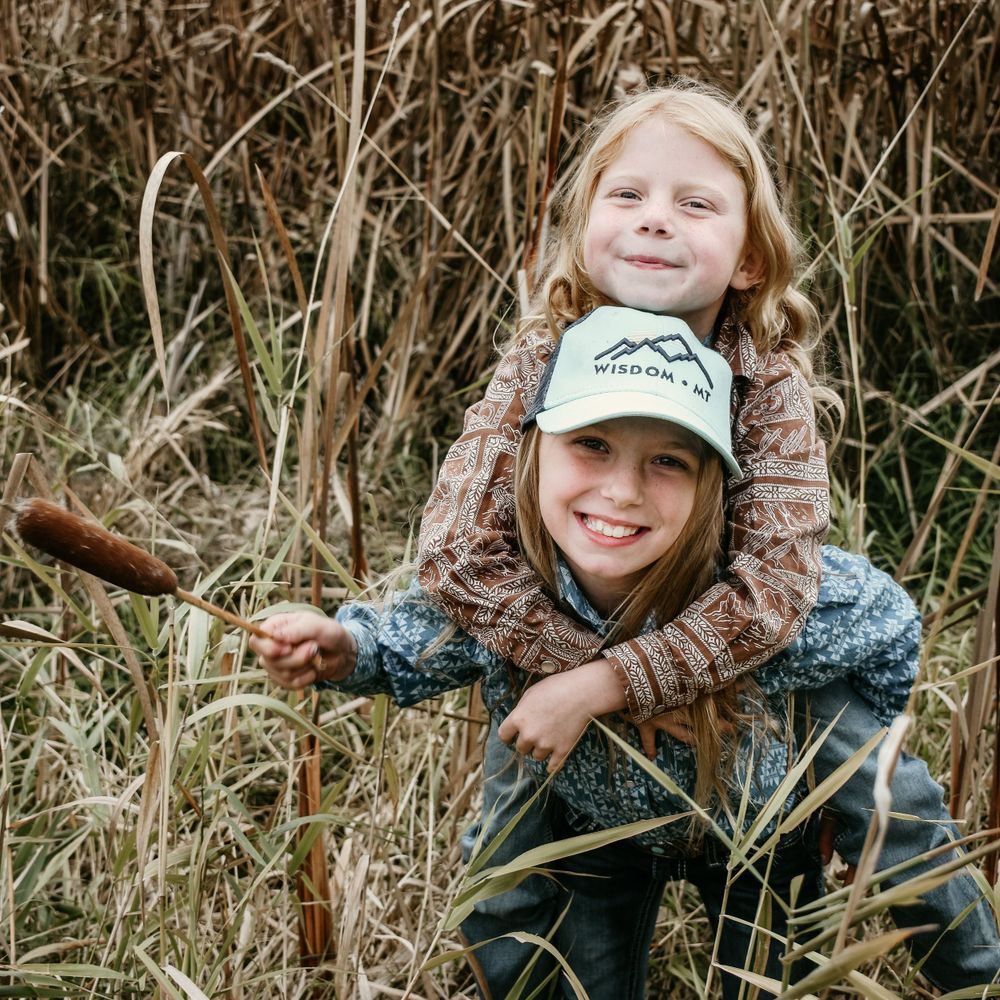 Two people having fun together in tall grass field.