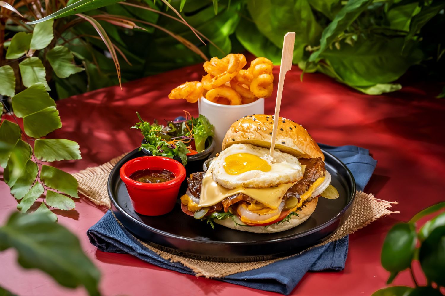 Sequence of burger platings with fries and garnishes on rustic settings.