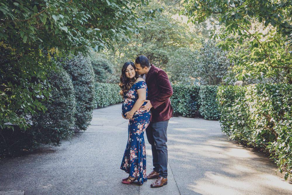 A romantic couple moment captured on a garden path surrounded by lush greenery.