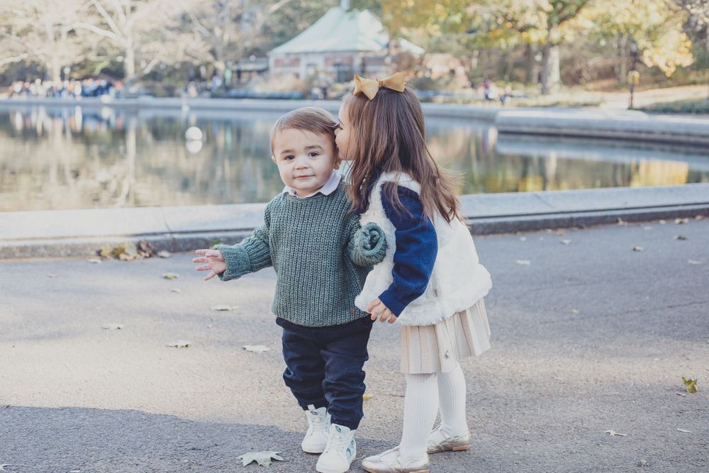 Children playing and walking together outdoors on a sunny day.