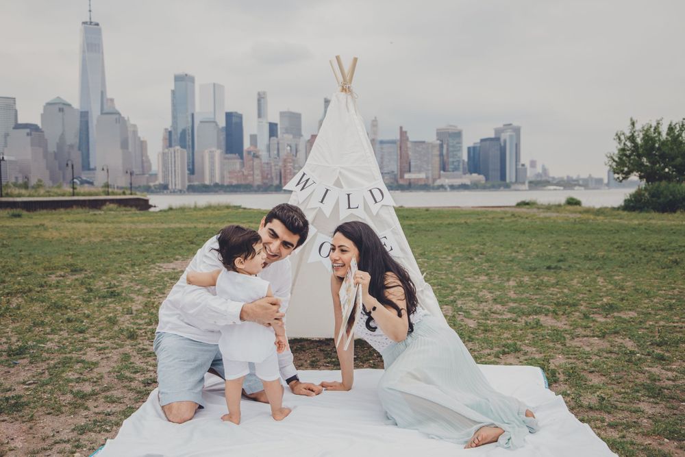 Family poses together with NYC skyline visible in background.