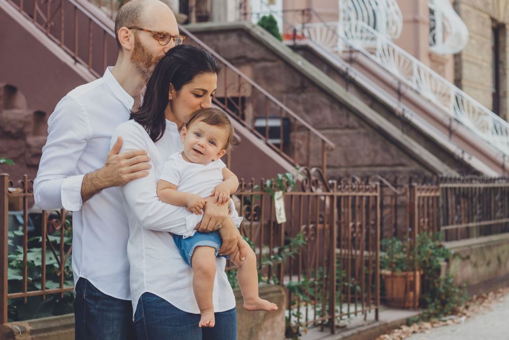 Intimate family moments captured on brownstone steps during urban photoshoot.