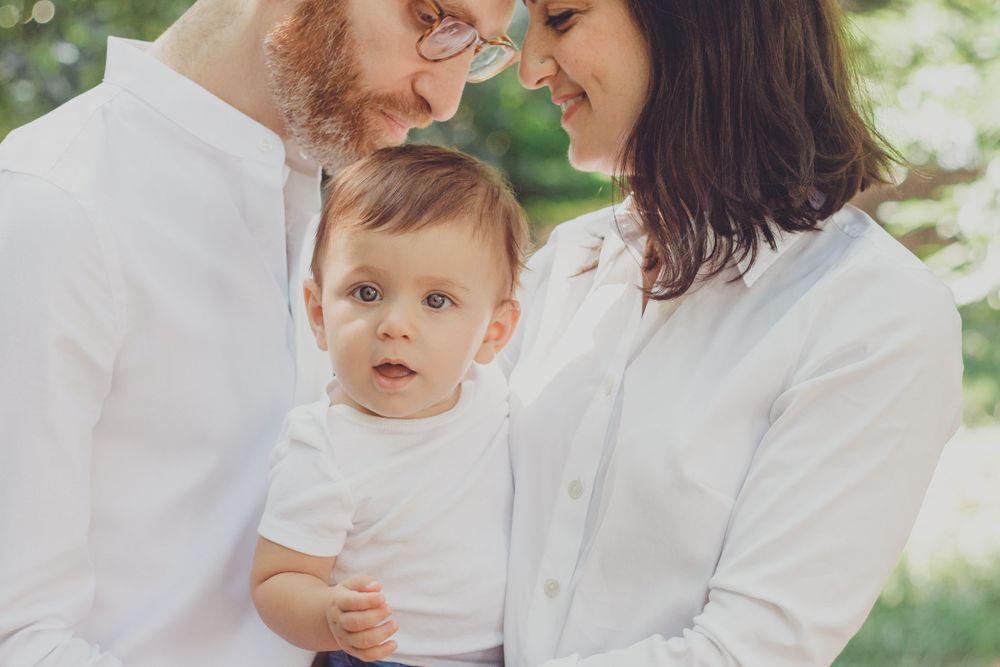 Tender family moments captured during outdoor summer photoshoot.