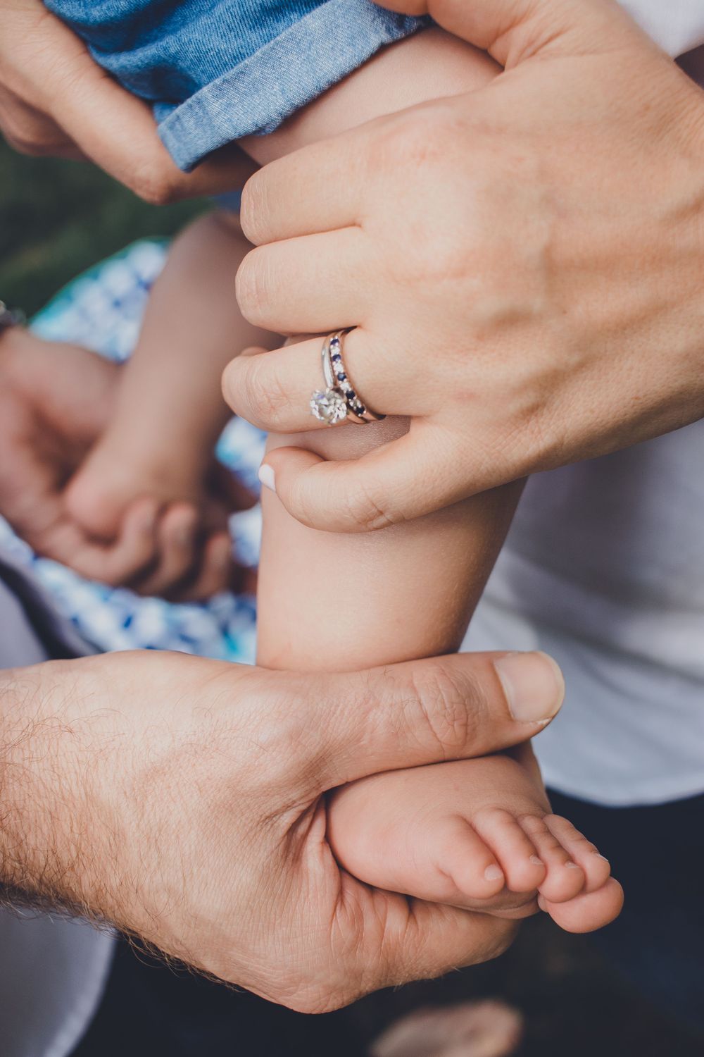 Close-up shots of hands holding and touching in an intimate family moment.