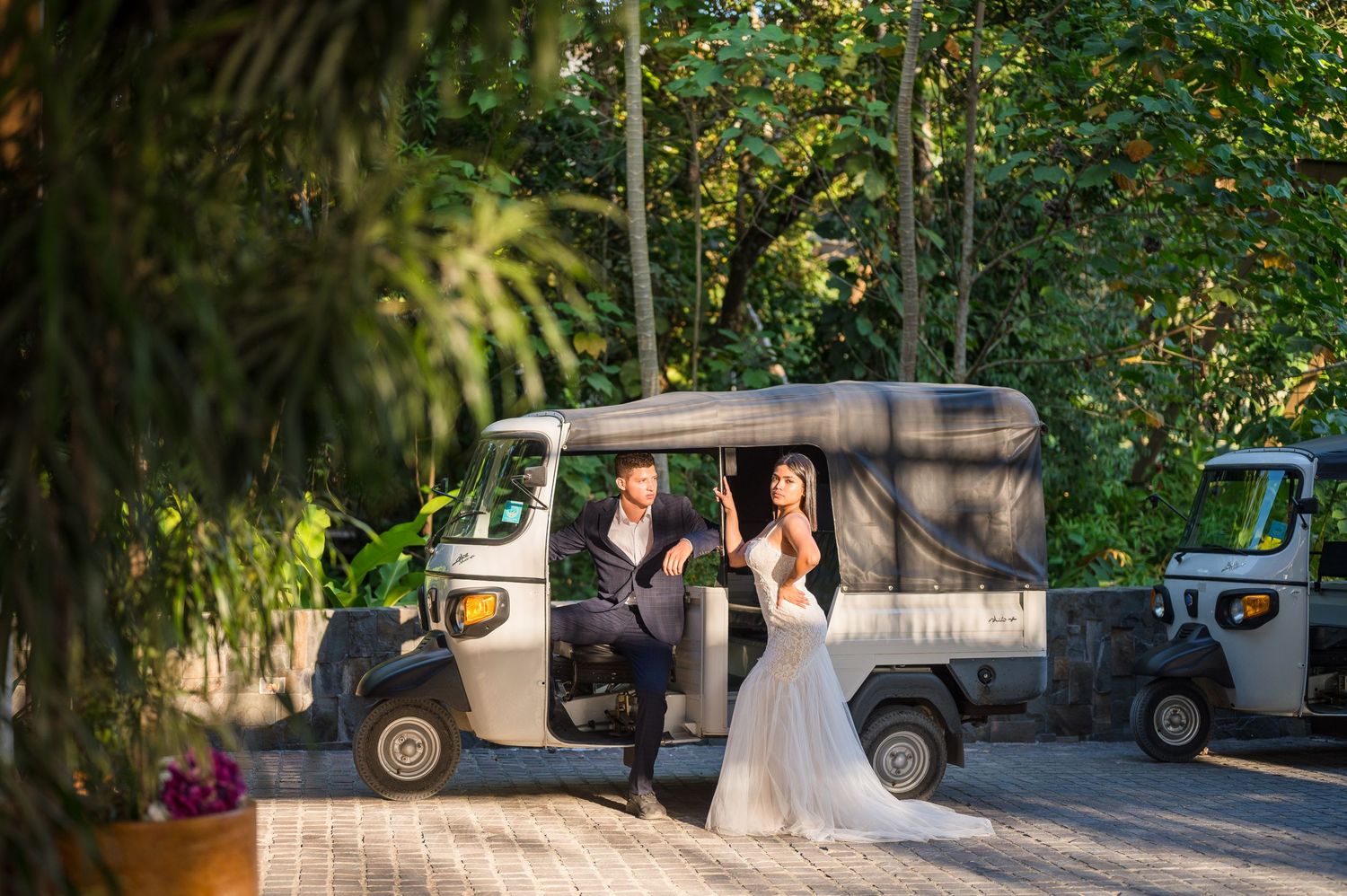 Couple posing in front of a golf cart at Botanika Osa Peninsula hotel entrance.