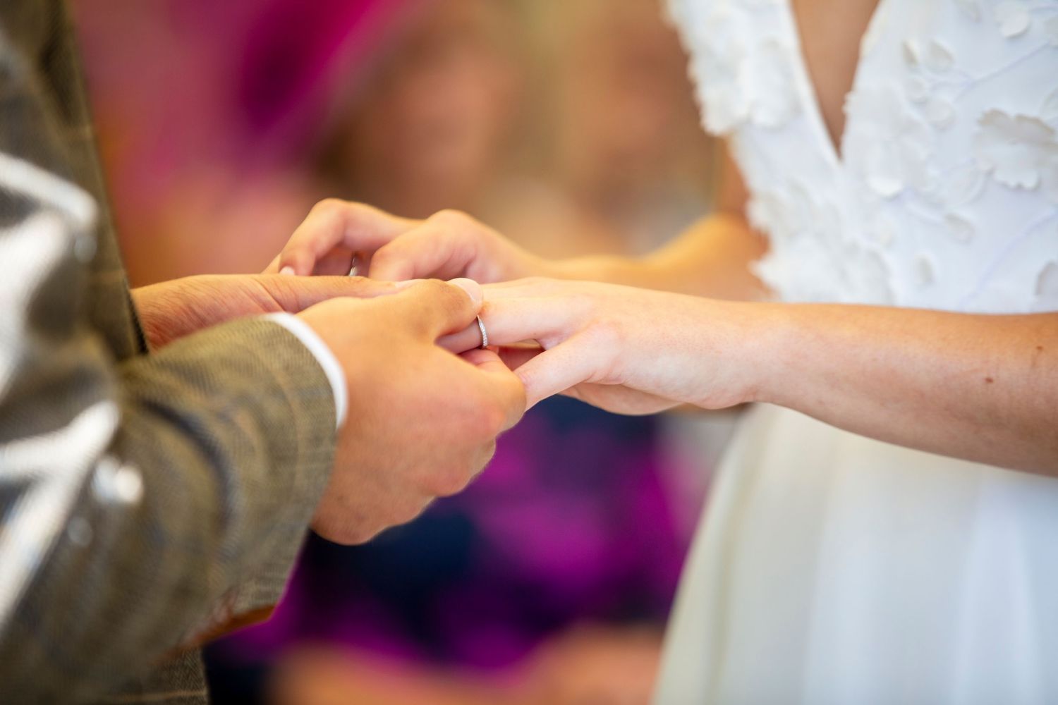 Close-up of hands exchanging wedding rings during an intimate ceremony.