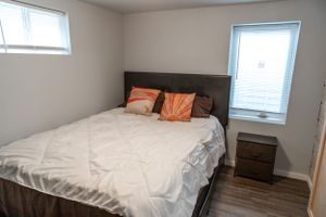 Bright bedroom with fresh white bedding and natural light from window.