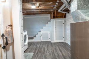 Industrial style basement space with exposed ceiling and modern grey flooring.