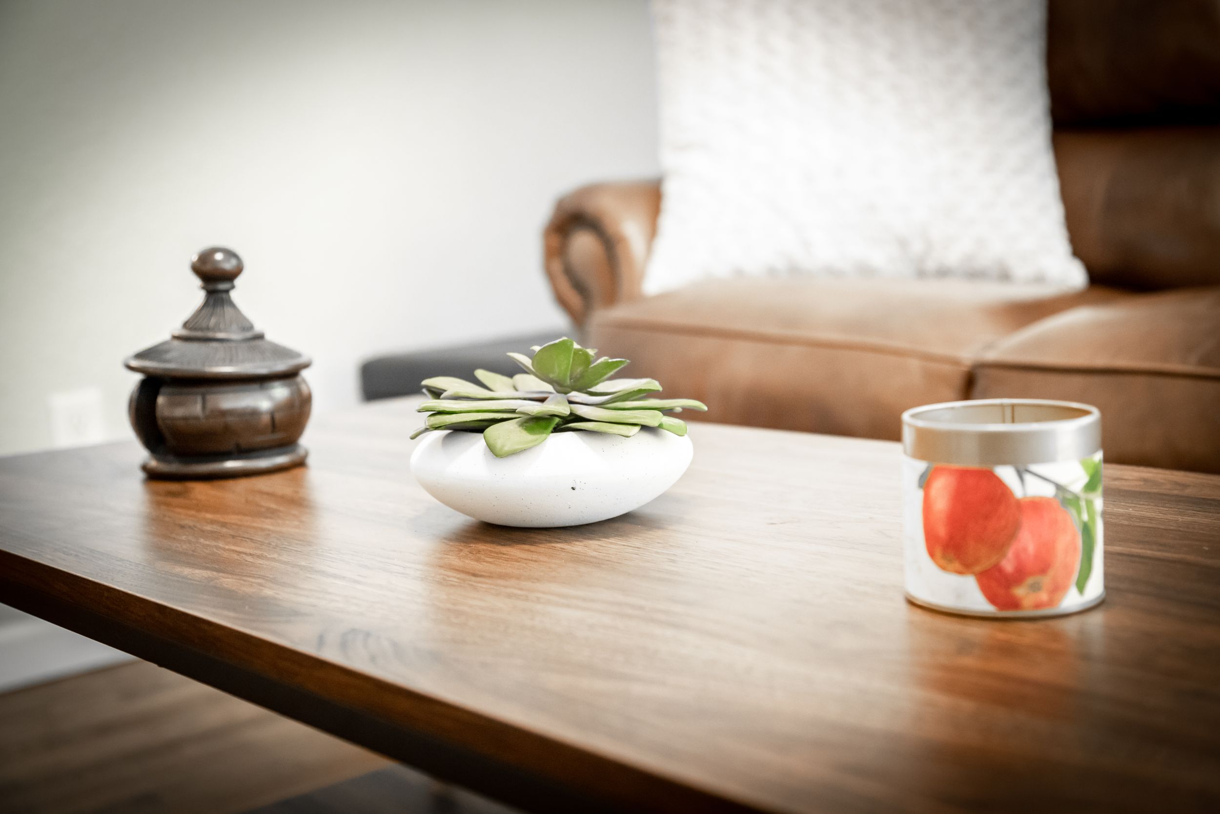 Wooden table displaying decorative items including a succulent plant and glass container.