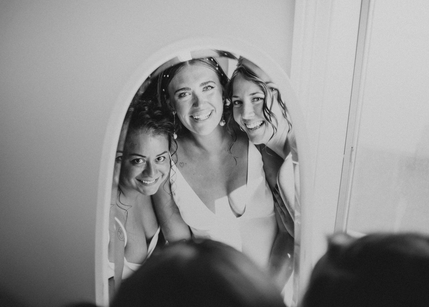 Black and white candid mirror reflection during wedding preparations.