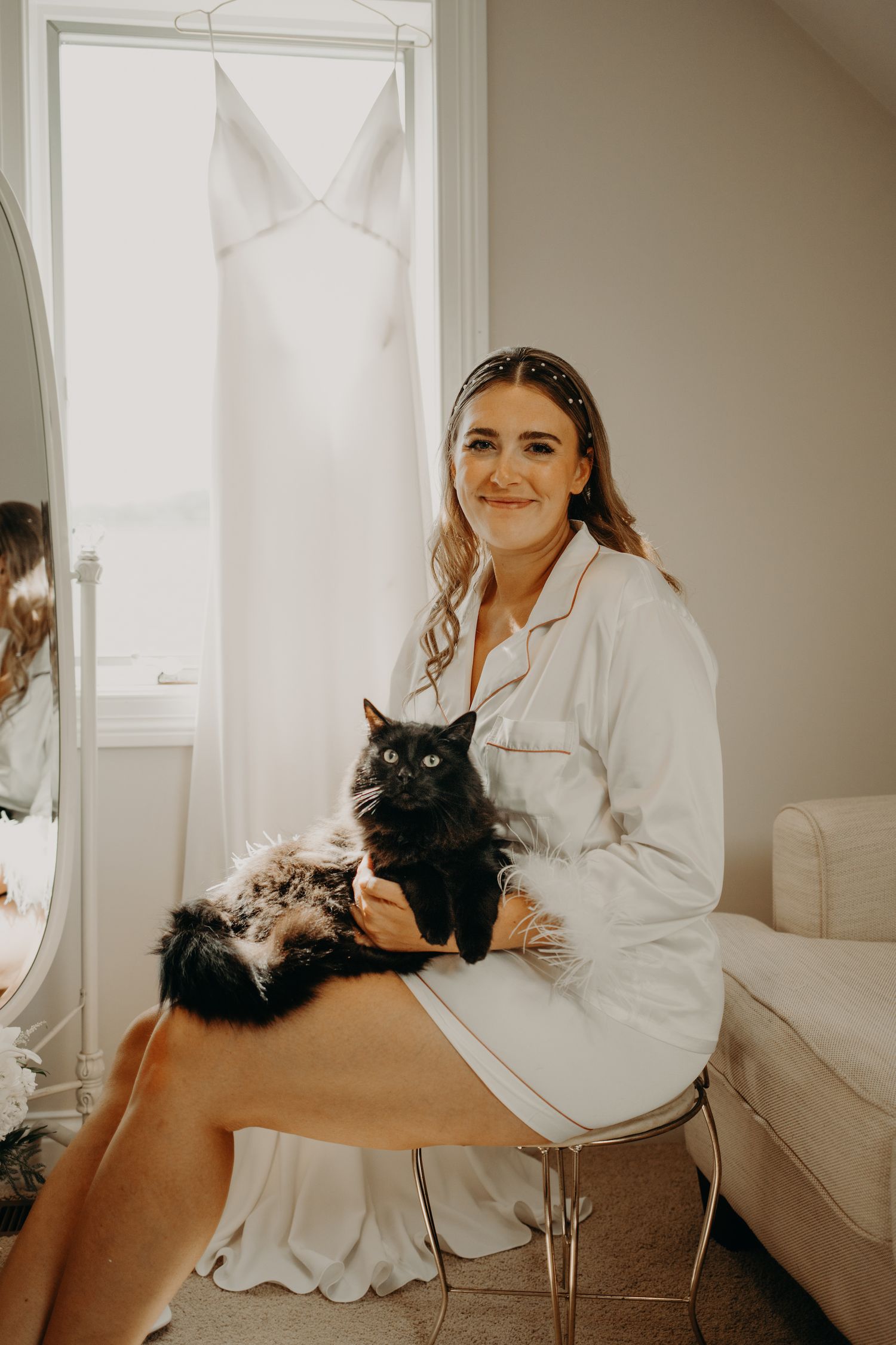 Wedding morning preparation scene with black cat and white decor in bright room.