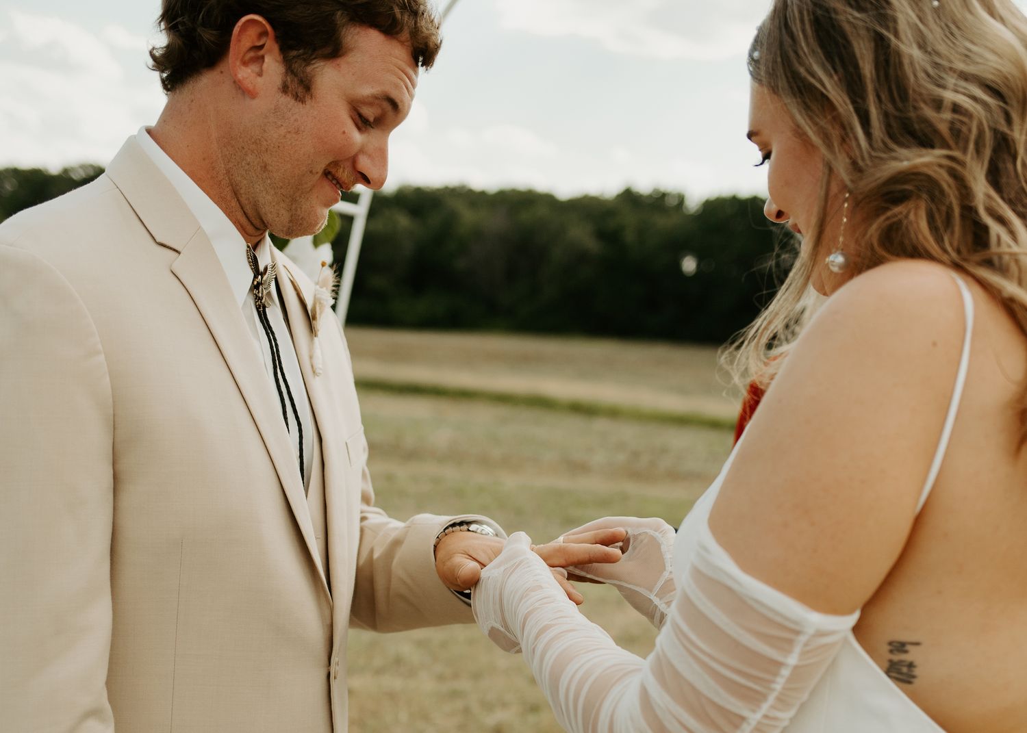 Close up of ring exchange during outdoor wedding ceremony.