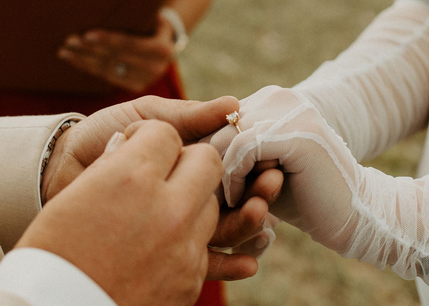 Close up of hands during wedding ring exchange ceremony.