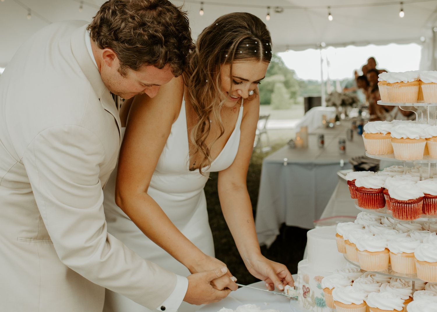 A candid moment of laughter and joy during a wedding reception under a tent.