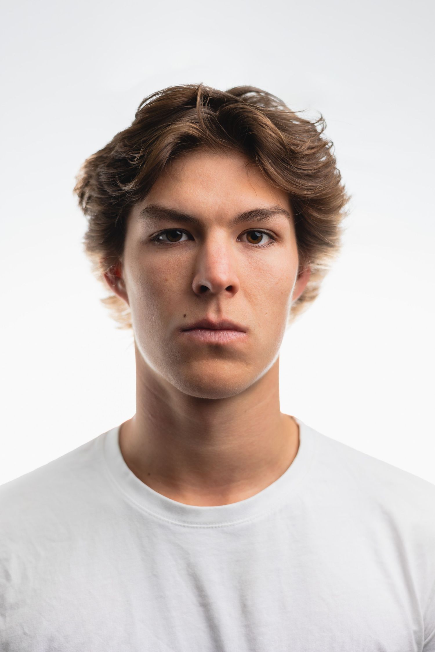Studio portrait of young person in white t-shirt against light background.