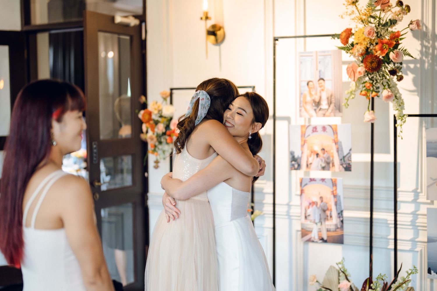 Wedding celebration in a bright venue with floral arrangements and decorative lighting.