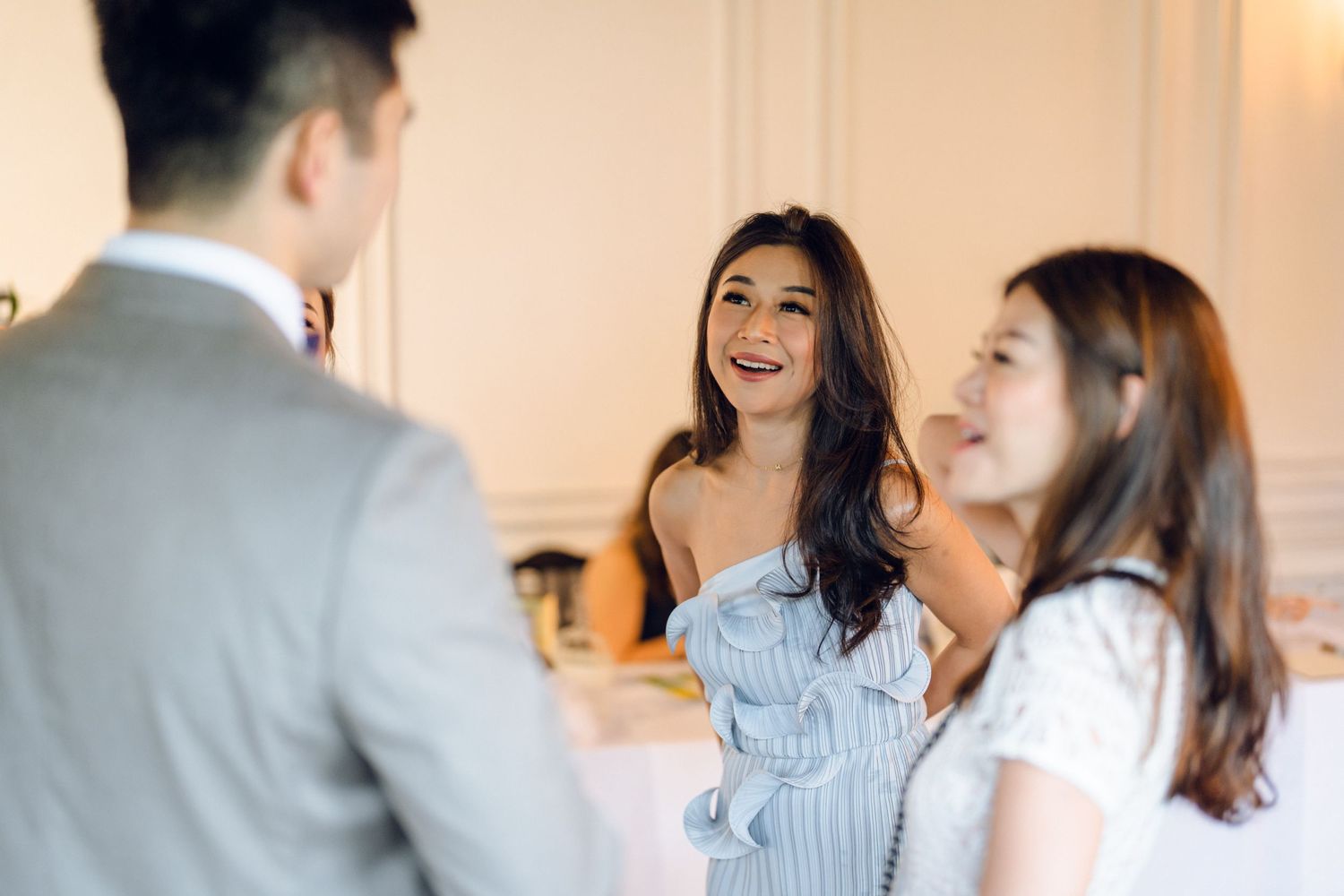 Guests enjoying conversation at an upscale restaurant table with soft lighting and formal place settings.