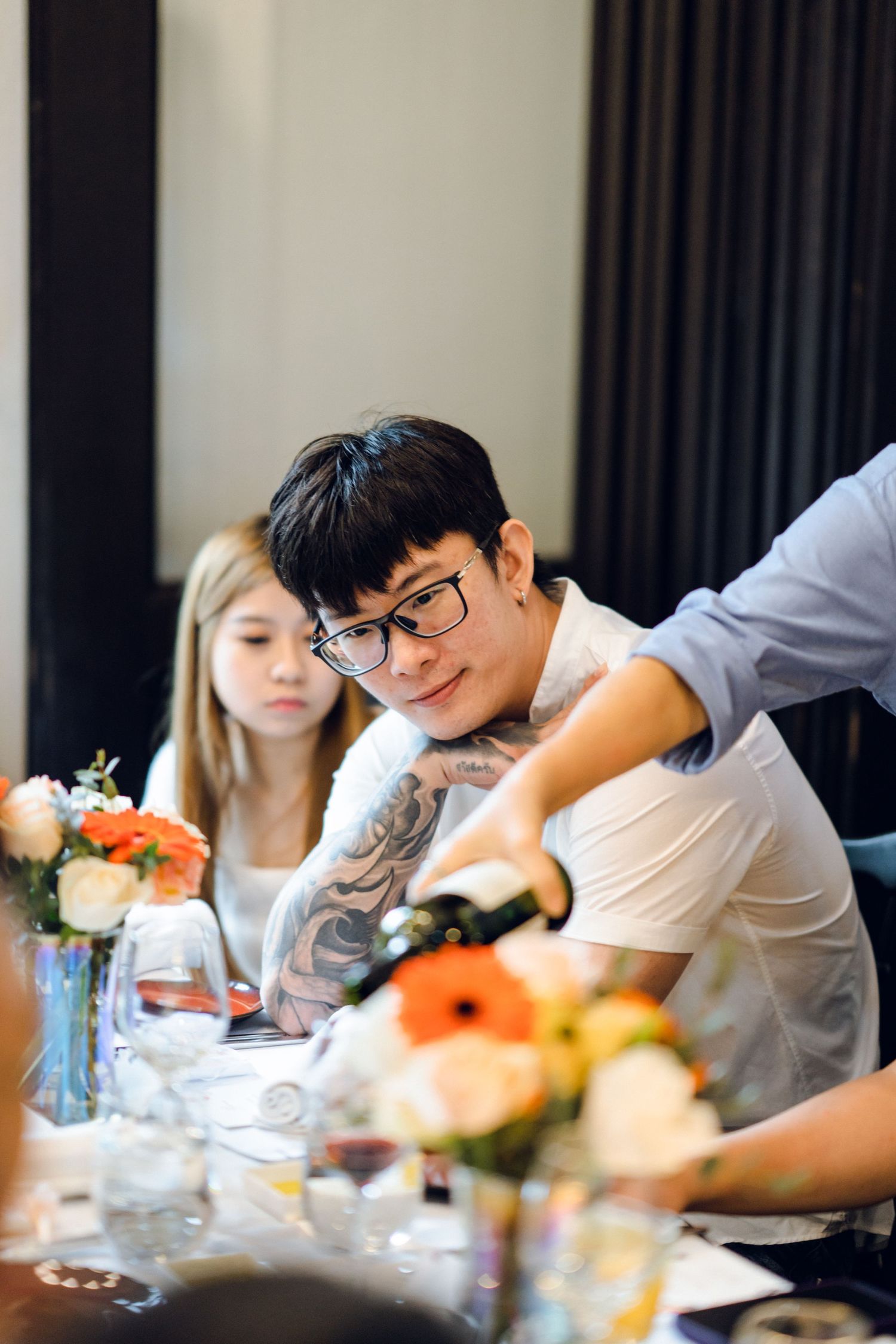 Restaurant guests sharing a lighthearted moment during an elegant dining experience.