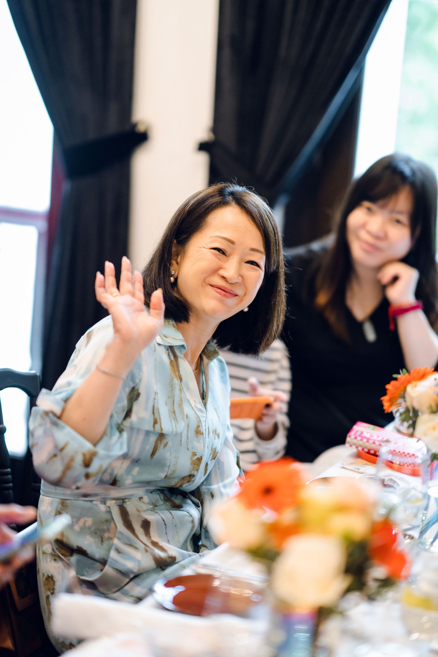 Joyful dining scene with guests laughing at an upscale restaurant table.