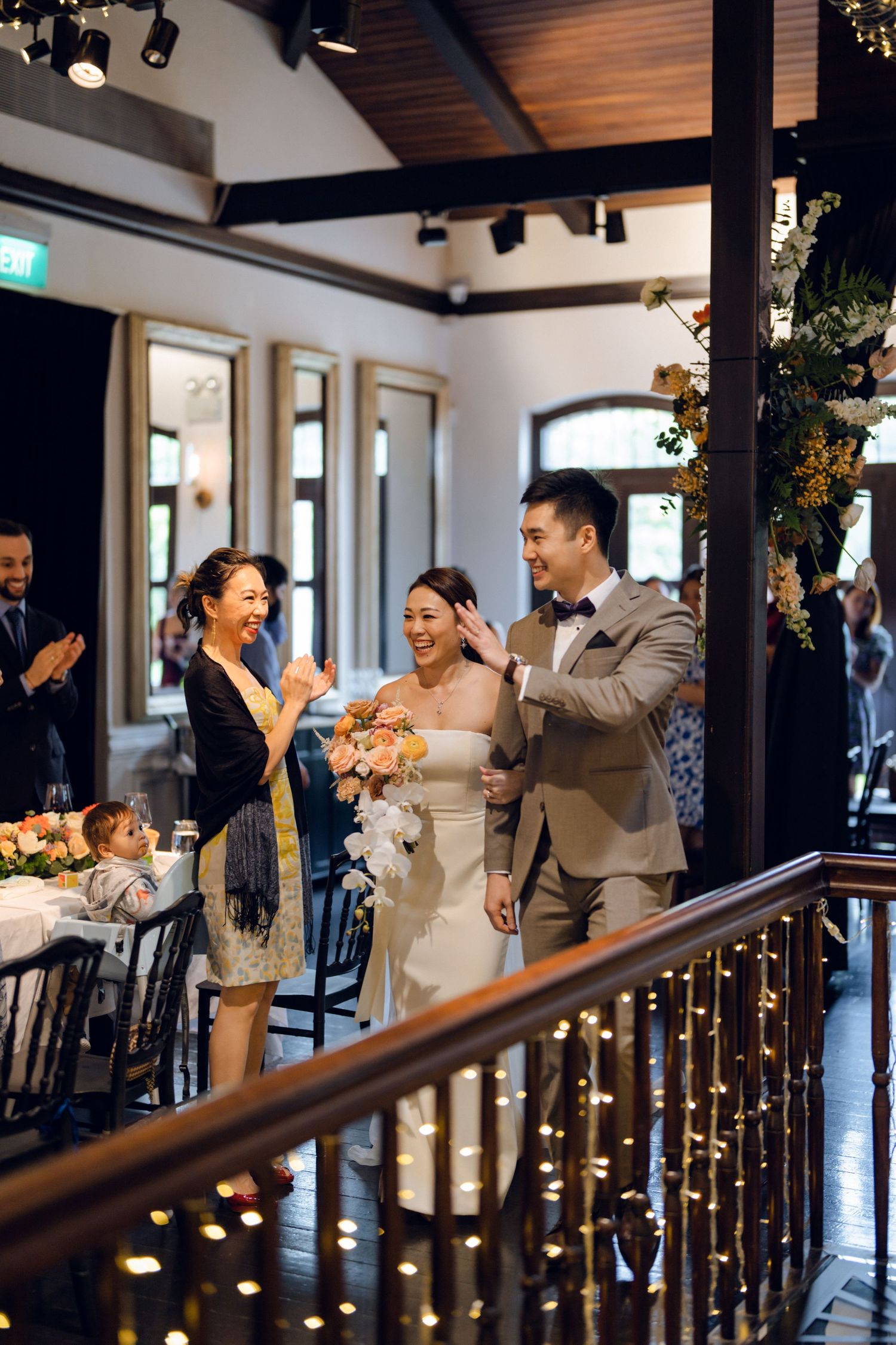 Celebratory gathering in a modern restaurant space with illuminated railings and wooden ceiling beams.