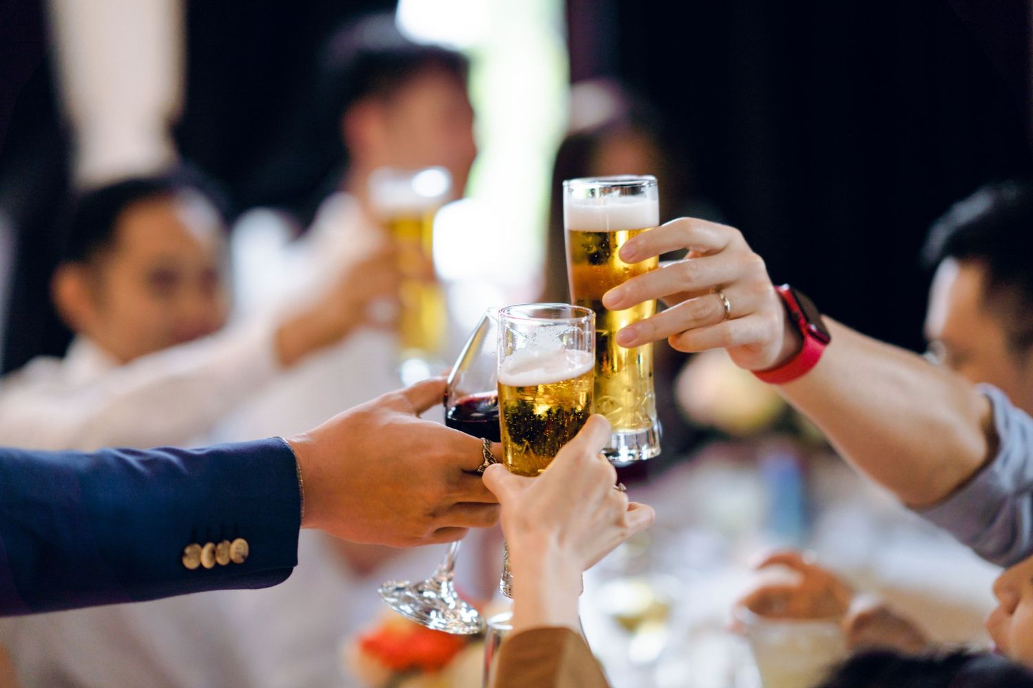 Wedding guests raise glasses for celebratory toast during reception.