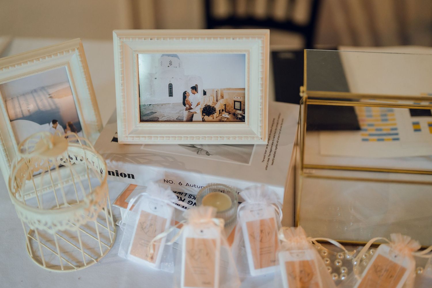 Wedding memorabilia and framed photos arranged on white linen tablecloth with rustic elements.