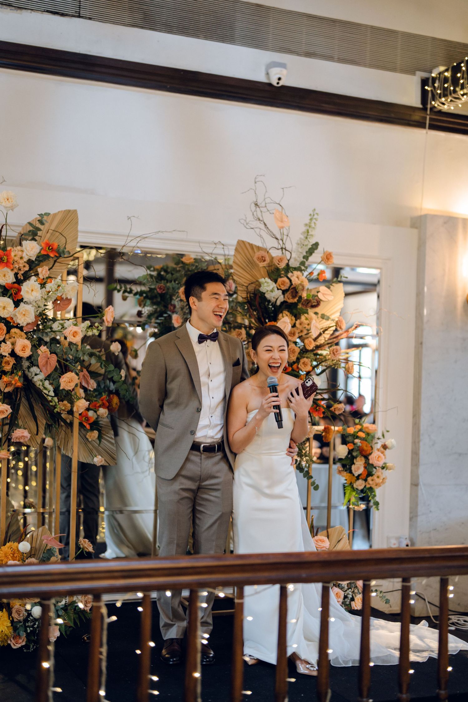 Wedding reception celebration captured from a balcony view showing joyful moments and floral decorations.