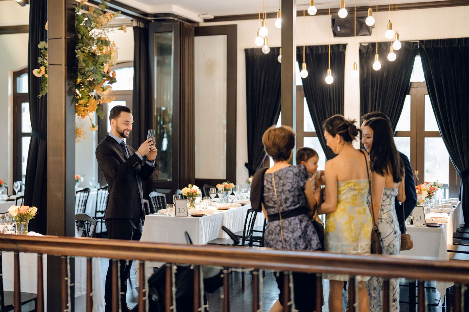 Elegant wedding venue interior with dark wood accents and hanging pendant lights creates a warm atmosphere.
