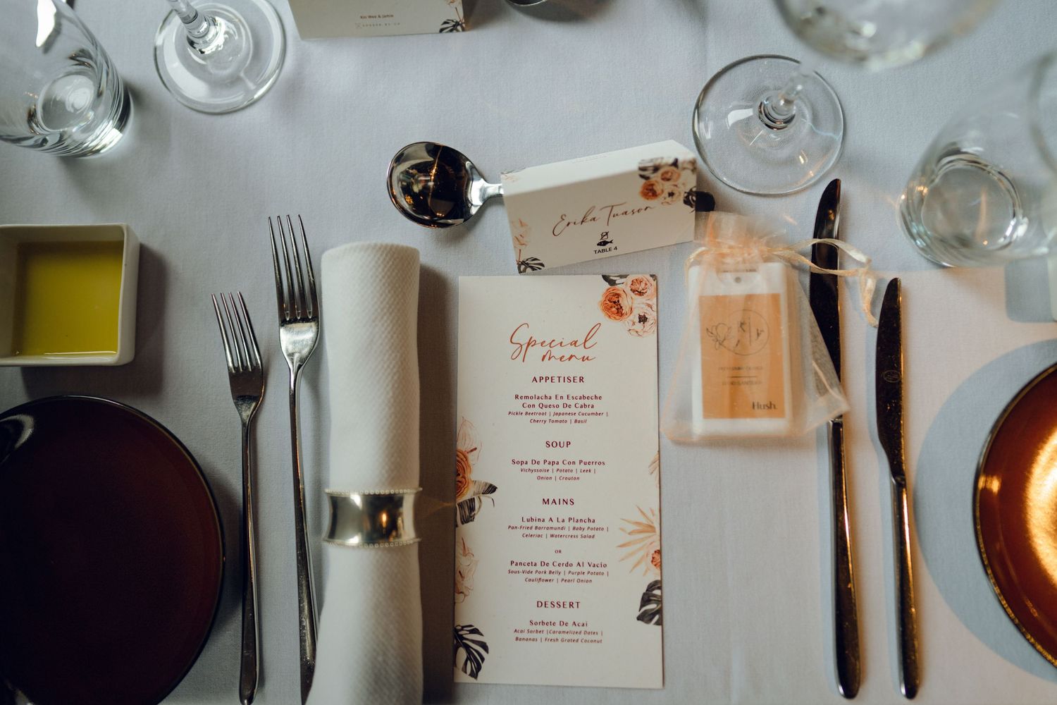 Wedding reception table settings feature elegant glassware and personalized menu cards.