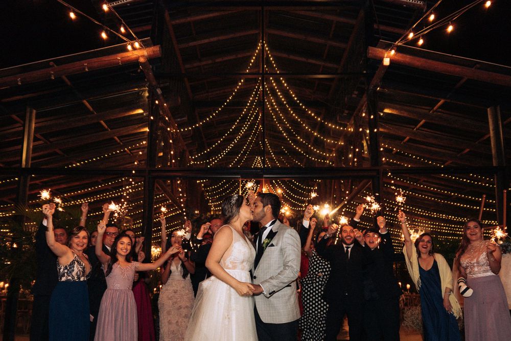Wedding reception with golden string lights illuminating the dance floor and celebrating guests