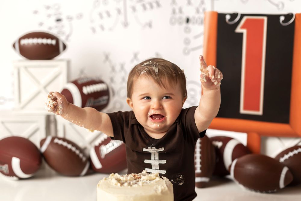 Sports themed first birthday setup with footballs and red number one decoration.