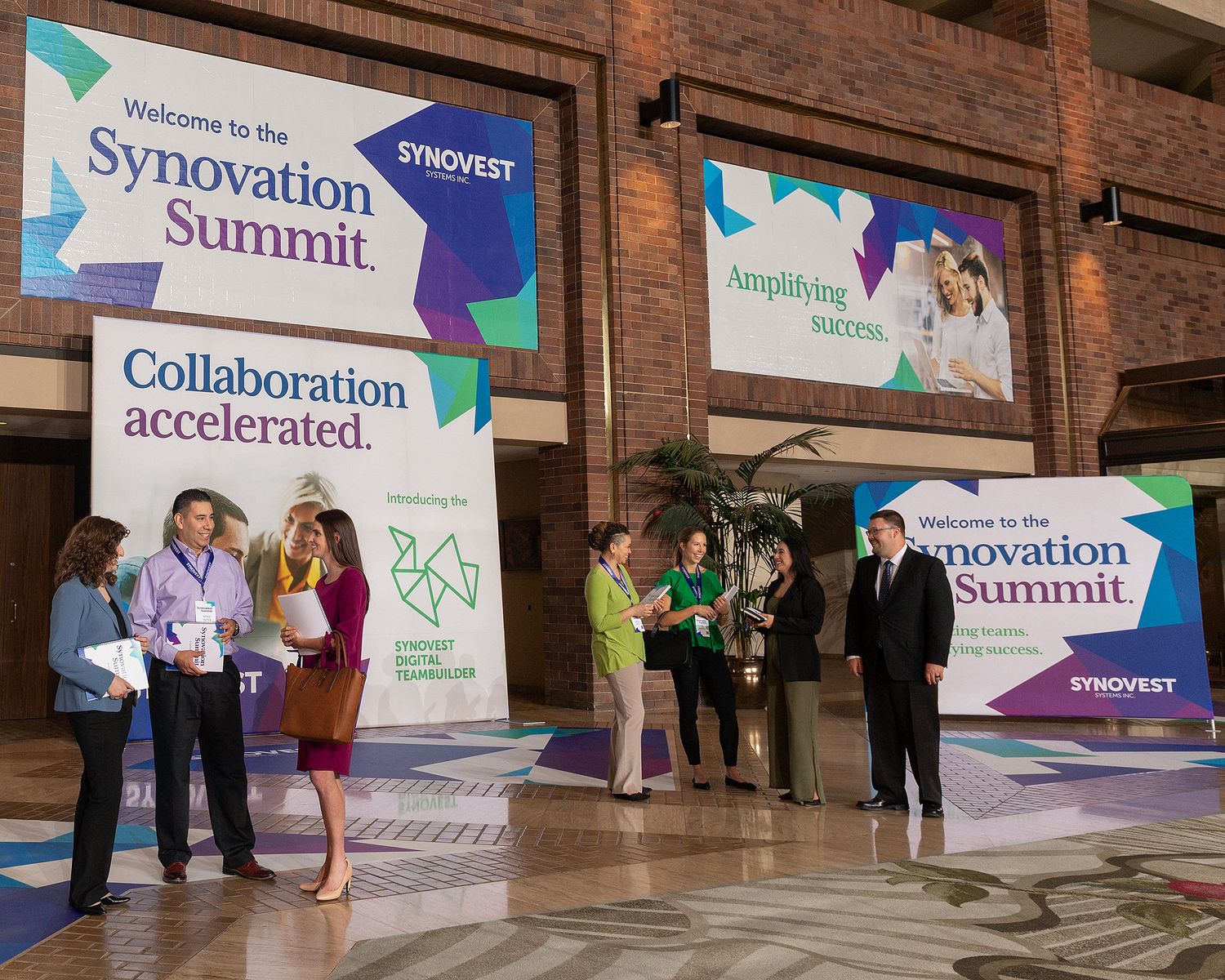 Many banners and standup graphics printed by a FedEx Office Commercial Print Center displayed in a convention center.