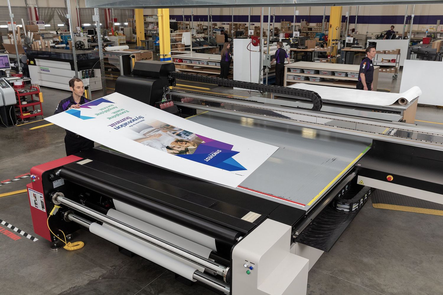 A large format printer at a FedEx Office Commercial Printing Center creates large graphics for a convention.
