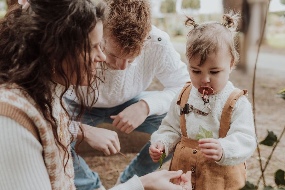 Close-up of family sitting together on ground sharing intimate moment outdoors.